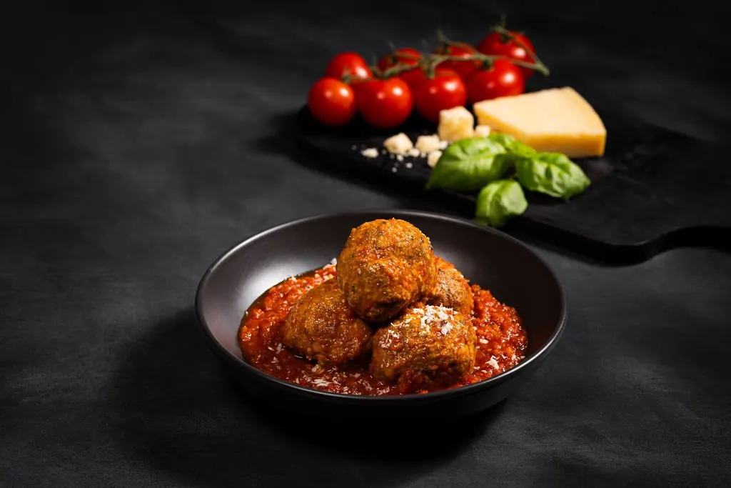 Meatballs in marinara with basil and parmesan